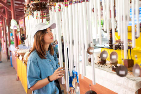 A young woman wearing a hat is walking in the market streets of an asian country,Thailand