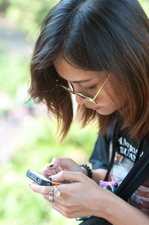 Close-up of female hands using modern smart phone while working,Young woman using a touchscreen smartphone with copy spaceの写真素材