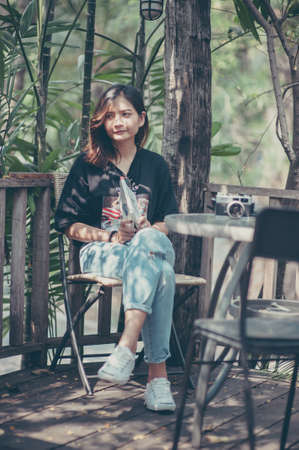 Young woman asian relax with reading a book and camera film in coffee cafe , Outdoor lifestyle&vintage tone pictureの写真素材