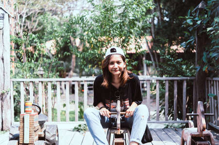 Young woman asian she rides a toy wood horse on the carousel with real pleasure.の写真素材