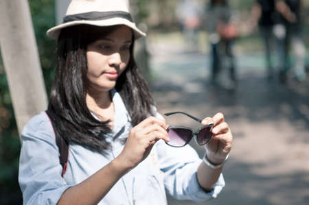 Beautiful young asian woman wearing round hat on a park ,travel in a summer dayのeditorial素材