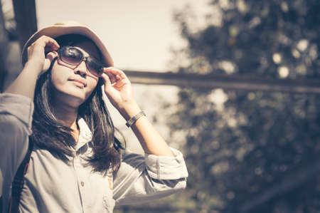 Beautiful young asian woman wearing round hat on a park ,travel in a summer dayの写真素材