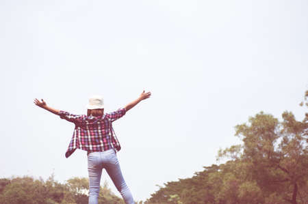 woman jumping enjoying relax on green grass and flower field in park