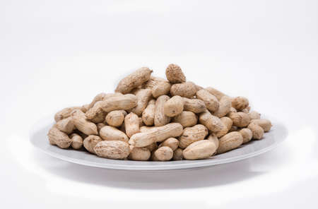 Dried peanuts on white plate at on white background