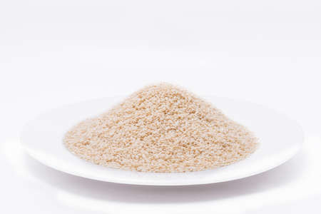 White Sesame Seeds on white plate at on white backgroundの写真素材