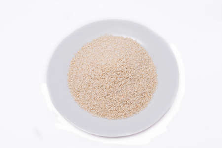 White Sesame Seeds on white plate at on white backgroundの写真素材