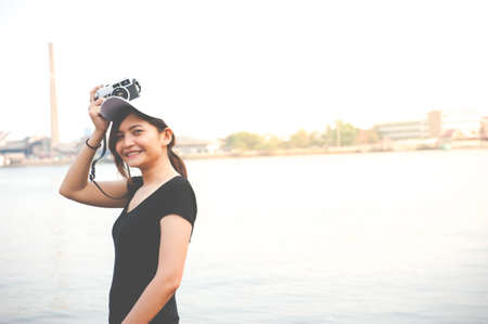 Hipster woman taking photos with retro film camera ,Girl Adventure Hangout Traveling Holiday Photography Conceptの写真素材