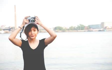 Hipster woman taking photos with retro film camera ,Girl Adventure Hangout Traveling Holiday Photography Conceptの写真素材