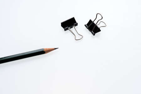 Copy space blank paper A4 and pencil and back binder clip on table white background ,top viewの写真素材