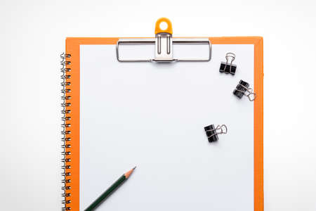 Copy space blank paper A4 and pencil and back binder clip on table white background, top viewの写真素材