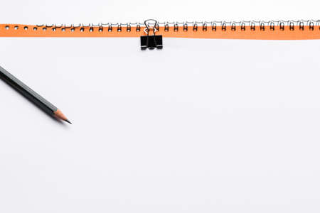 Copy space blank paper A4 and pencil and back binder clip on table white background ,top viewの写真素材