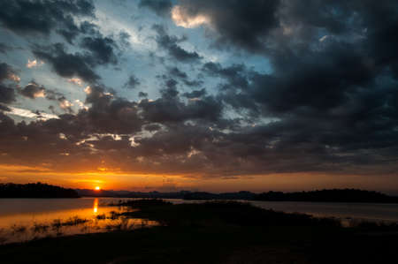 colorful dramatic sky with cloud at sunset. over silhouette mountainsの写真素材