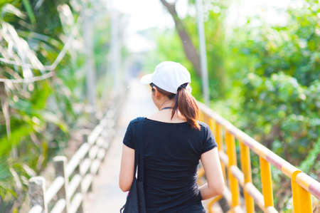 Portrait of a beautiful young smiling girl,Attractive young woman enjoying her time outside on  walkway in park with sunsetの写真素材