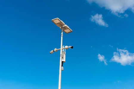 CCTV camera with blue sky background. Close-up of outdoor surveillance cameras on a street pole,...