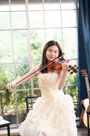 Violinist woman : Portrait of a young female playing the violin.の写真素材