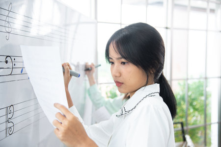 female student sitting taking notes music teacher.の写真素材
