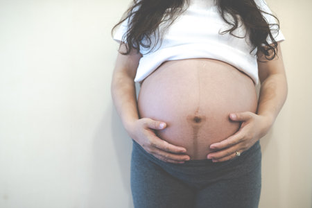 Pregnant woman feeling happy at home while taking care of her child.の写真素材
