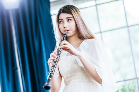 Portrait of Young Female Musician Playing Clarinet. Rehearsal before performing on stage.の写真素材