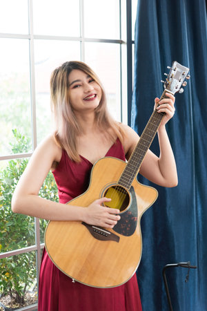 Beautiful young asian woman playing acoustic guitar . fashion lifestyleの写真素材