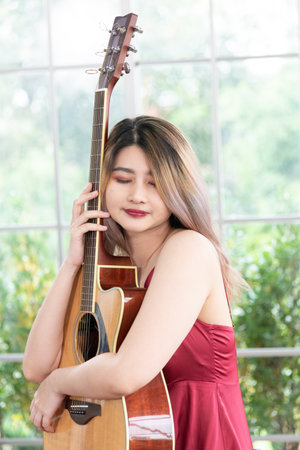 Beautiful young asian woman playing acoustic guitar . fashion lifestyle