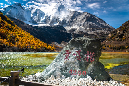view of autumn highland snow mountain of Yading Nature Reserve, snow-capped mountains, crystal clear lakes, vast grasslands, colorful forests, Shangri-La Town, Daocheng, Sichuan, Chinaの写真素材