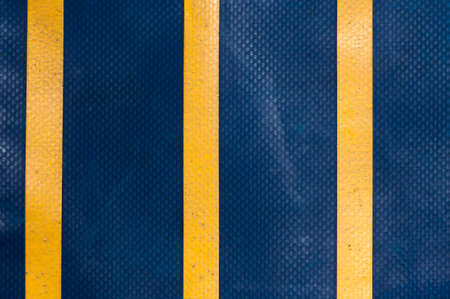 Abstract background of a blue truck tarpaulin with yellow stripes.の写真素材