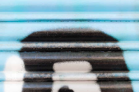 Abstract background, roller door decorated with graffiti.