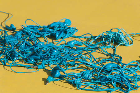 Blue headphones against yellow background