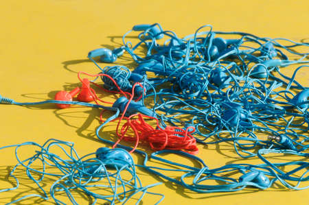 Blue and red headphones against yellow background.の写真素材