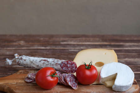 Mediterranean delicacy, salami and cheese with red tomato as food backgrounds.