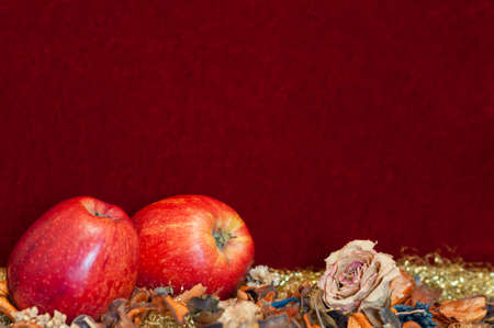 Christmas decoration apples with dried rose against red velvet with Copy Space.の写真素材