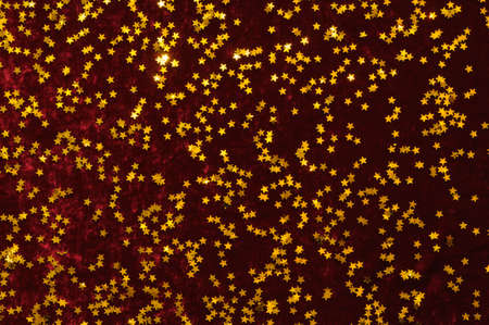 Background Christmas decoration, golden star on red velvet.