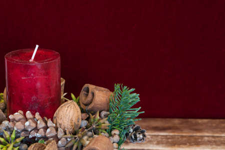 Background Christmas decoration, red candle in front of red velvet and copy space.