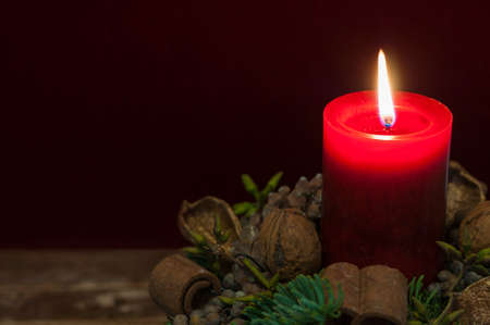 Background Christmas decoration, red candle with candlelight in front of red velvet and copy space.の写真素材