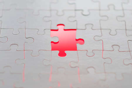 Symbol of solutions of business concepts, missing puzzle piece with a red glowing background.