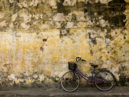 Bicycle slightly on a yellow house wall, Hoi An , Vietnam.の写真素材