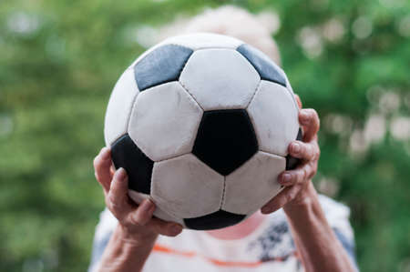 Active senior woman catches football. Close up of hands and Soccer.の写真素材