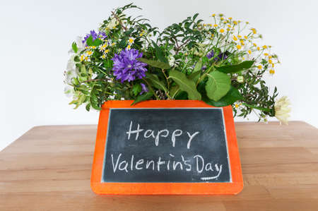 Flower bouquet and blackboard with Valentine greetings, Happy Valentin`s Day.の写真素材