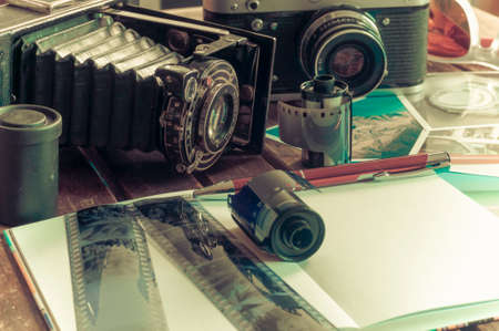 Old retro cameras on a table with photographs, negatives and films with Copy Space.の写真素材