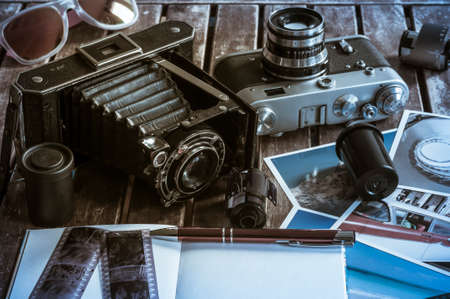 Old retro cameras on a table with photographs, negatives and films with Copy Space.