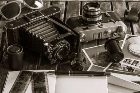 Old retro cameras on a table with photographs, negatives and films with Copy Space.の写真素材