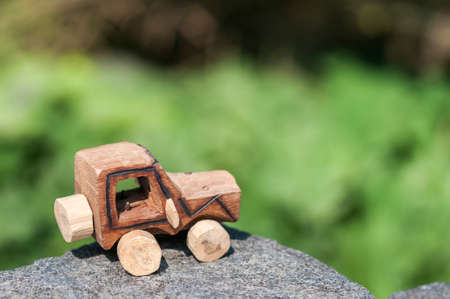 Wooden SUV, toy car in an extreme landscape.の写真素材