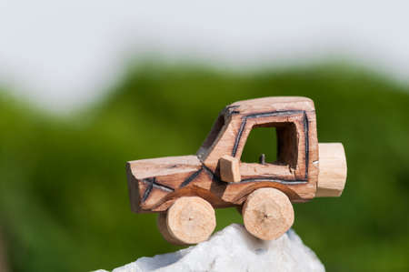 Wooden SUV, toy car in an extreme landscape.