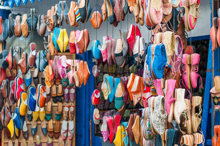 Colorful shoes hang in front of a market stall in a souk.の写真素材