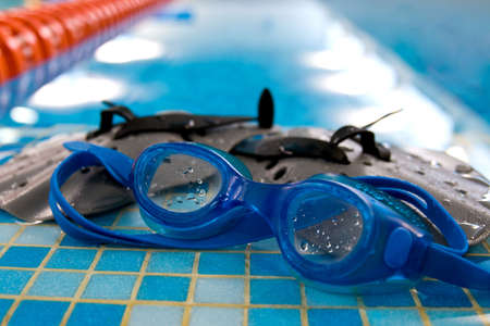 glasses and paddle for swim lay on the coast of swimming poolの写真素材