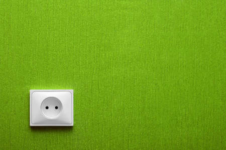 The electric socket in a green wall in the cornerの写真素材