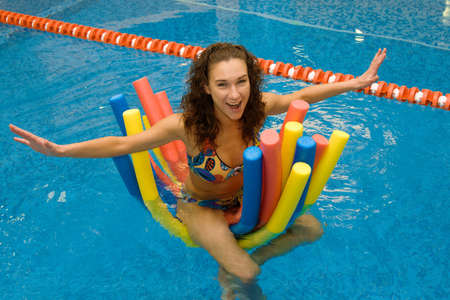 happy girl in water on aqua noodles