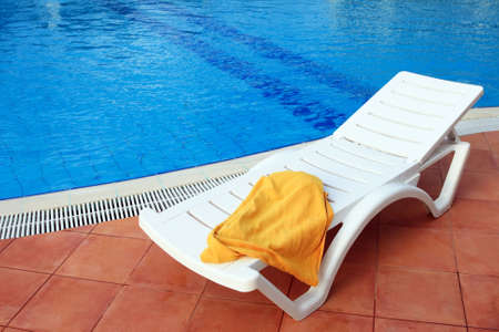 relax chair near the pool with a yellow towelの写真素材