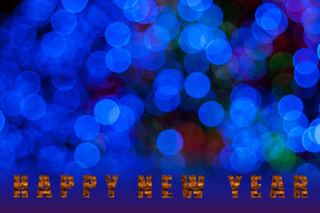 Text Happy New Year on Defocused Blue holiday background.