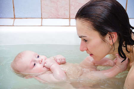 Mother with baby in a bathroom. Love concept